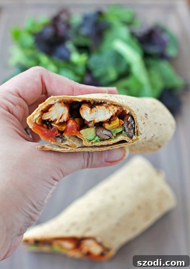 Close-up of a perfectly rolled Spicy Southwest Chicken Wrap, showcasing its rich filling.