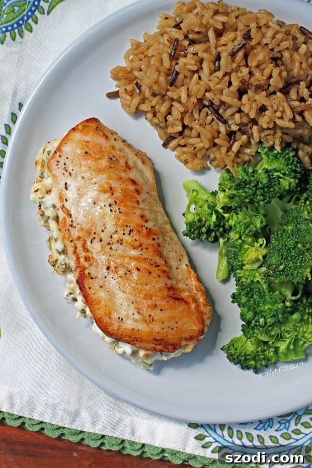 Cream Cheese and Herb Stuffed Chicken served with fluffy rice and steamed broccoli florets for a complete meal.
