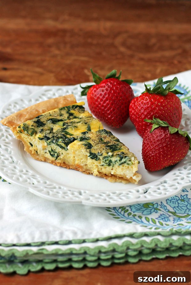 Spinach Feta Quiche slice plated with strawberries
