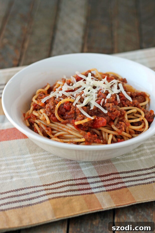 Spaghetti with Weeknight Bolognese Sauce in a ceramic bowl, garnished with parsley