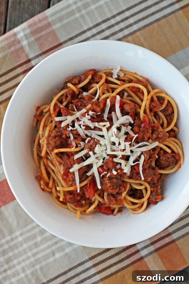 Close-up of spaghetti with Weeknight Bolognese sauce, topped with fresh Parmesan cheese