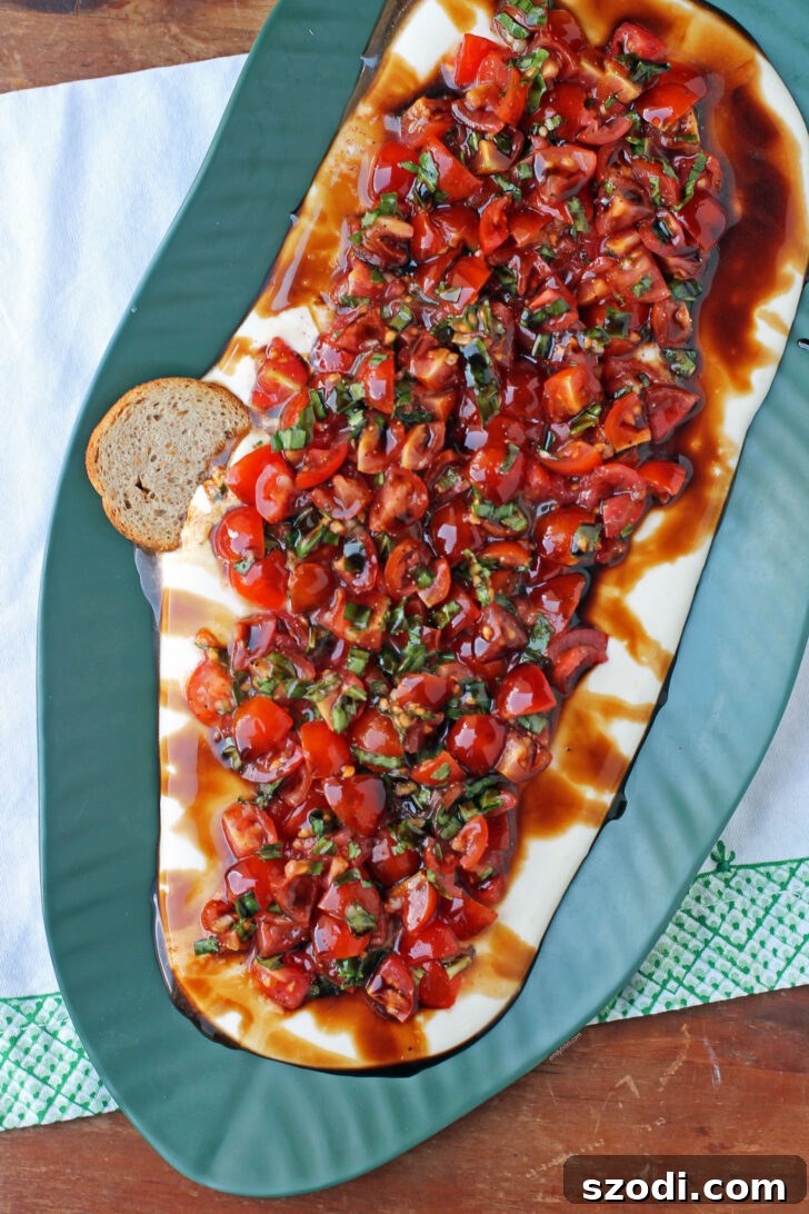 Close-up of Whipped Feta Bruschetta Dip with a piece of toast dipped in, showcasing its creamy texture