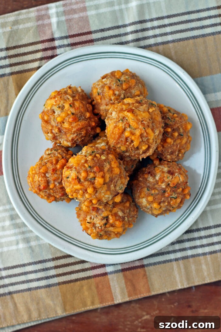 Overhead shot of Bisquick Chicken Sausage Balls perfectly stacked on a white plate, ready for serving