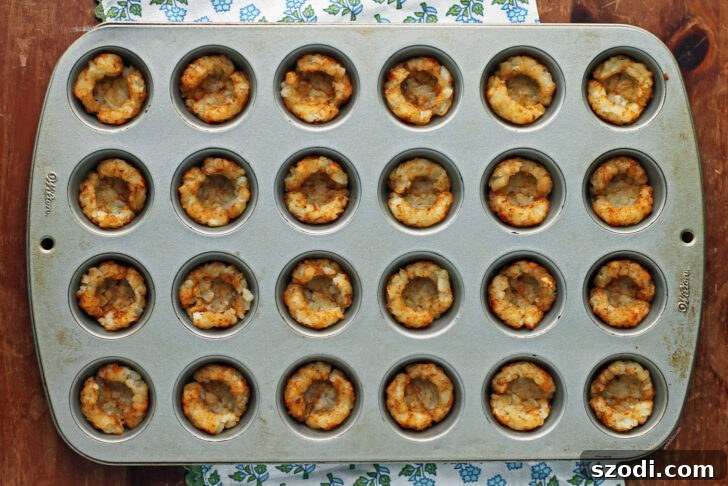 A batch of baked Mini Tater Tot Cups, golden and ready for toppings.
