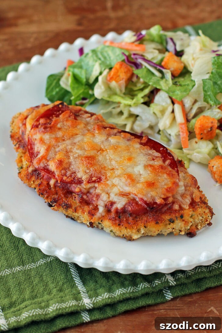 Delicious Chicken Pizzesan plated with fresh salad