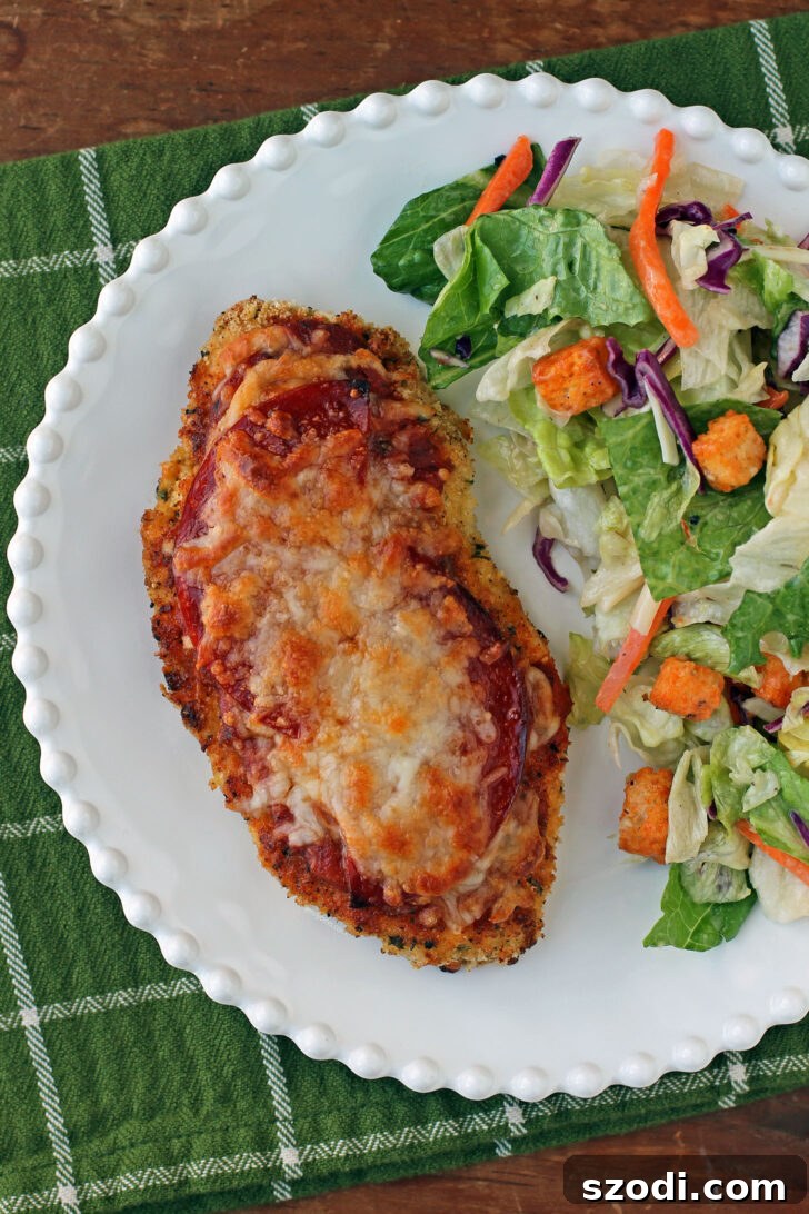 Overhead view of Chicken Pizzesan on a plate with salad