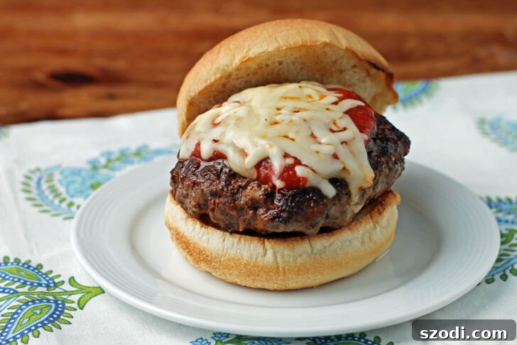 Delicious Stuffed Pizza Burger plated with the lid removed, revealing melted cheese and filling.