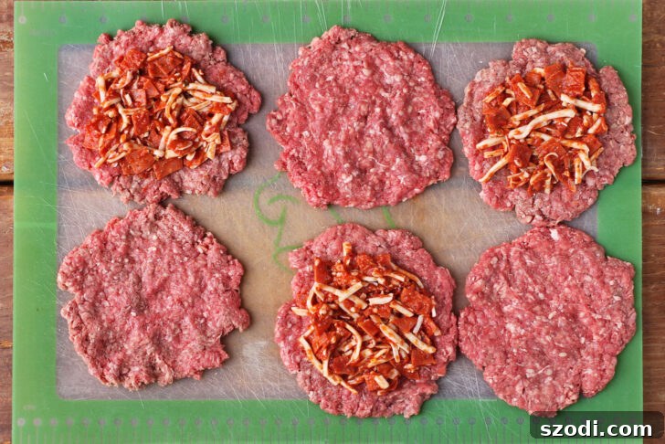 Stuffed Pizza Burgers prepared and cut open, showcasing the pepperoni, sauce, and cheese filling.